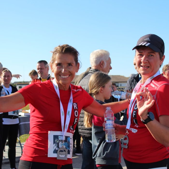 Glade løbere med røde t-shirts, numre og medaljer, Solstråleløbet.
